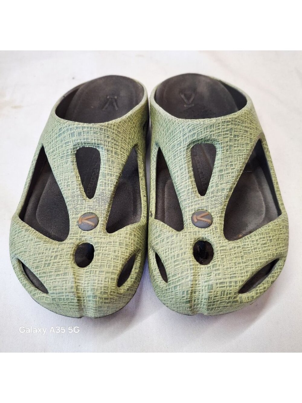 green KEEN Shanti clogs feature a textured, foam upper with distinctive cutout d